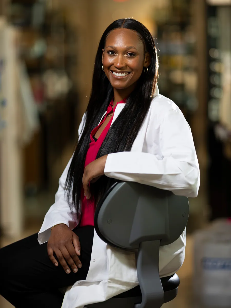 A profile photo of Autumn Hampton, a student at UGA majoring in sociology, biochemistry, and molecular biology. She is pictured in a while lab coat.