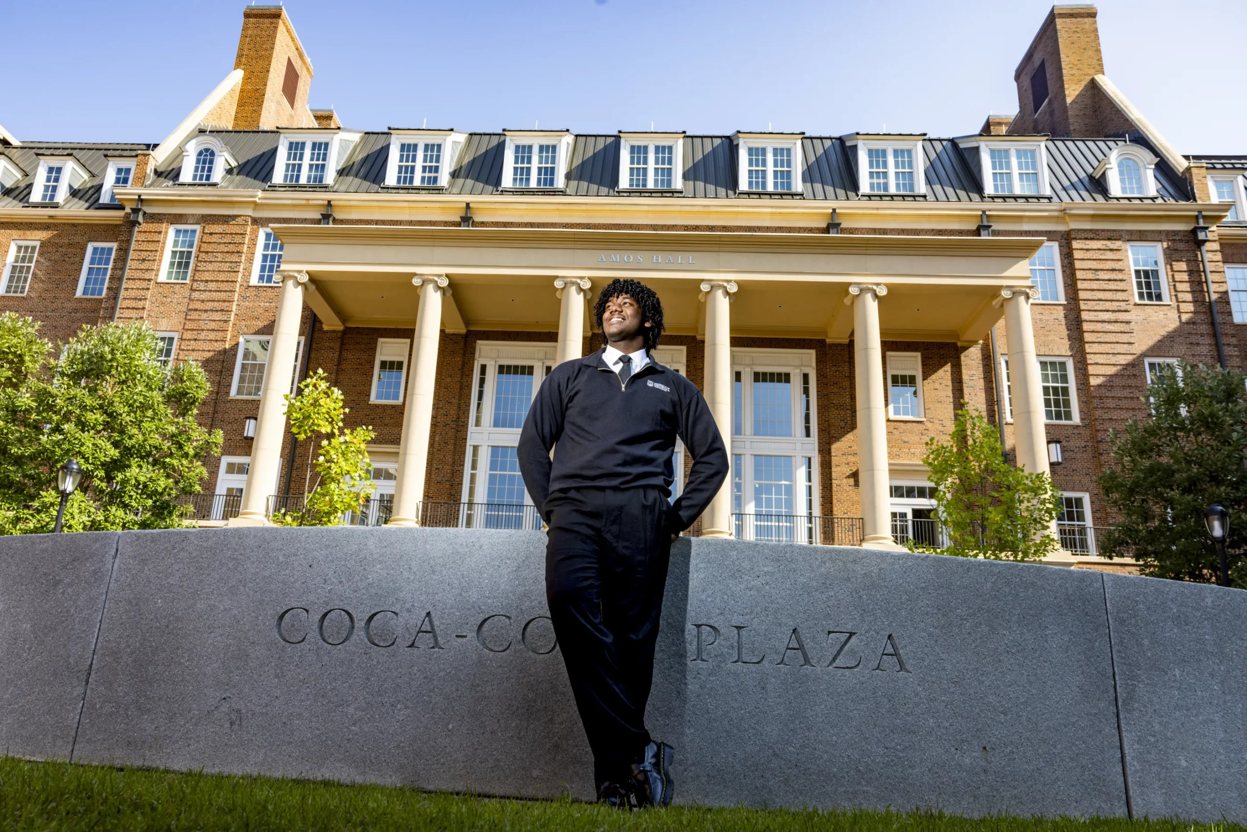 Trey Wilson stands in front of the Coca-Cola Plaza sign and a columned brick building