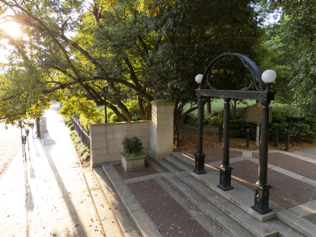 The iron Arch at the University of Georgia on North Campus, framed by trees in morning light