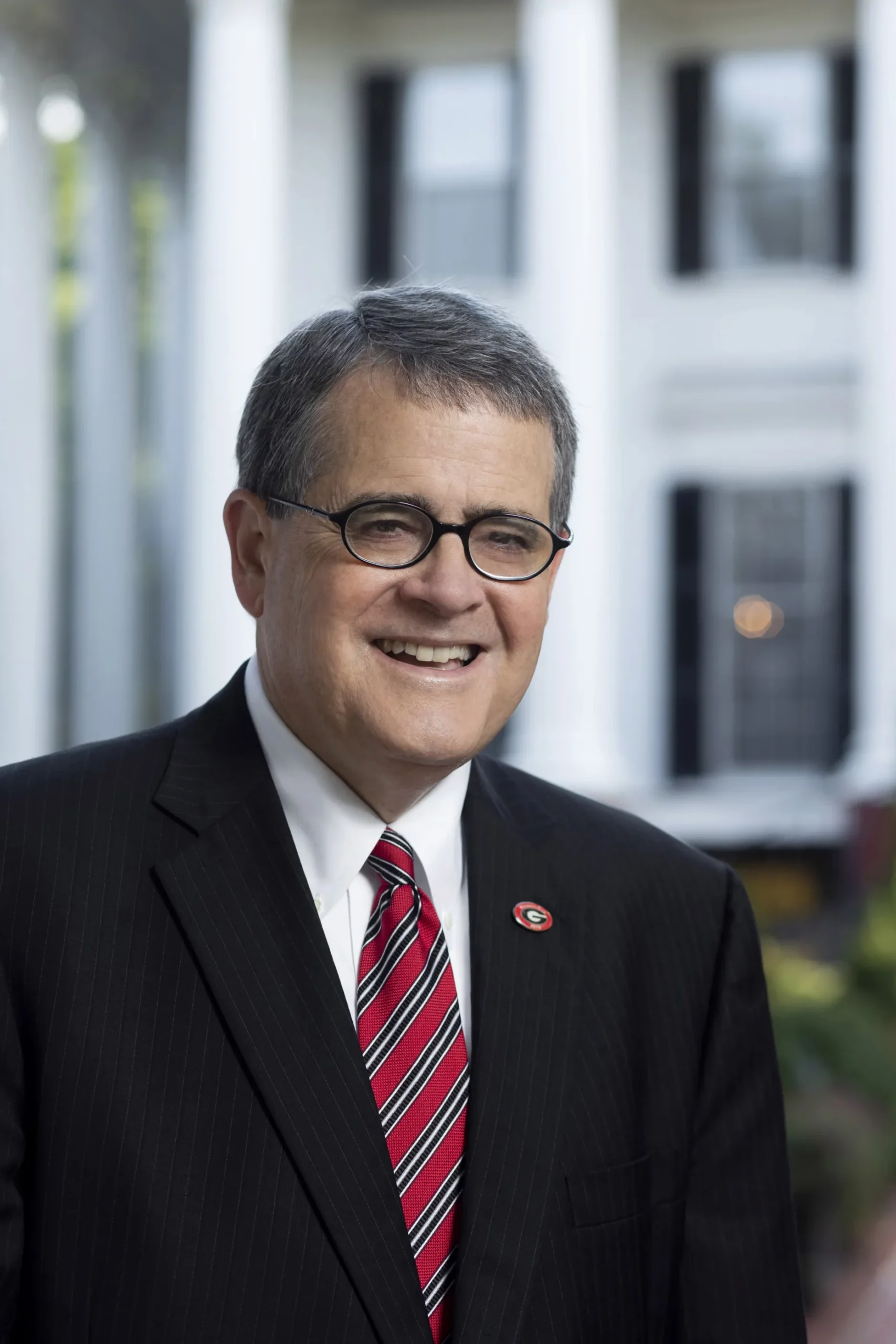 President Jere W. Morehead, smiling, in front of a white-columned building