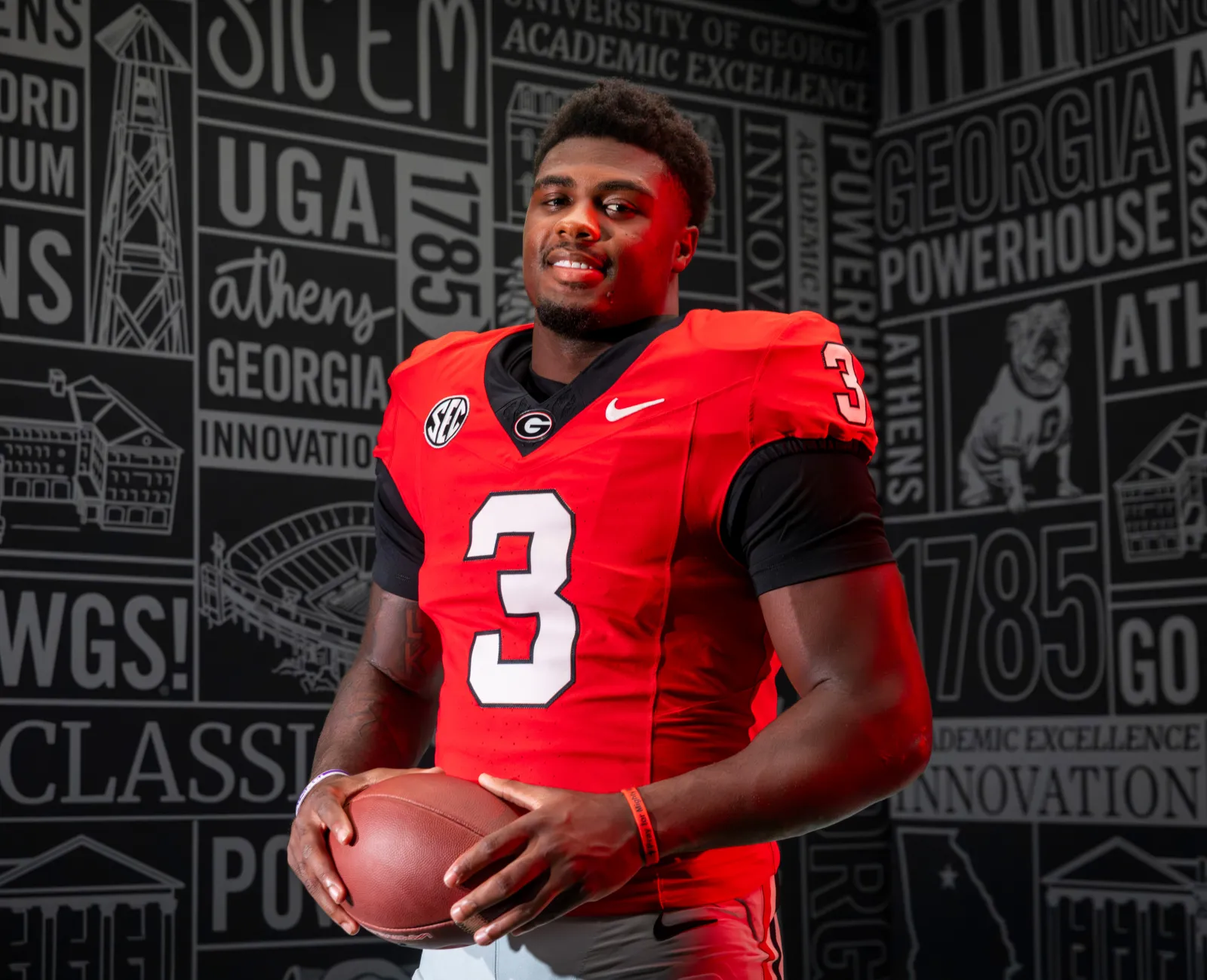 CJ Allen in his red Georgia football jersey, number 3, holding a football