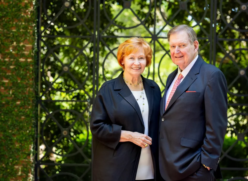 Doug and Kay Ivester stand together in front of an ornate iron gate